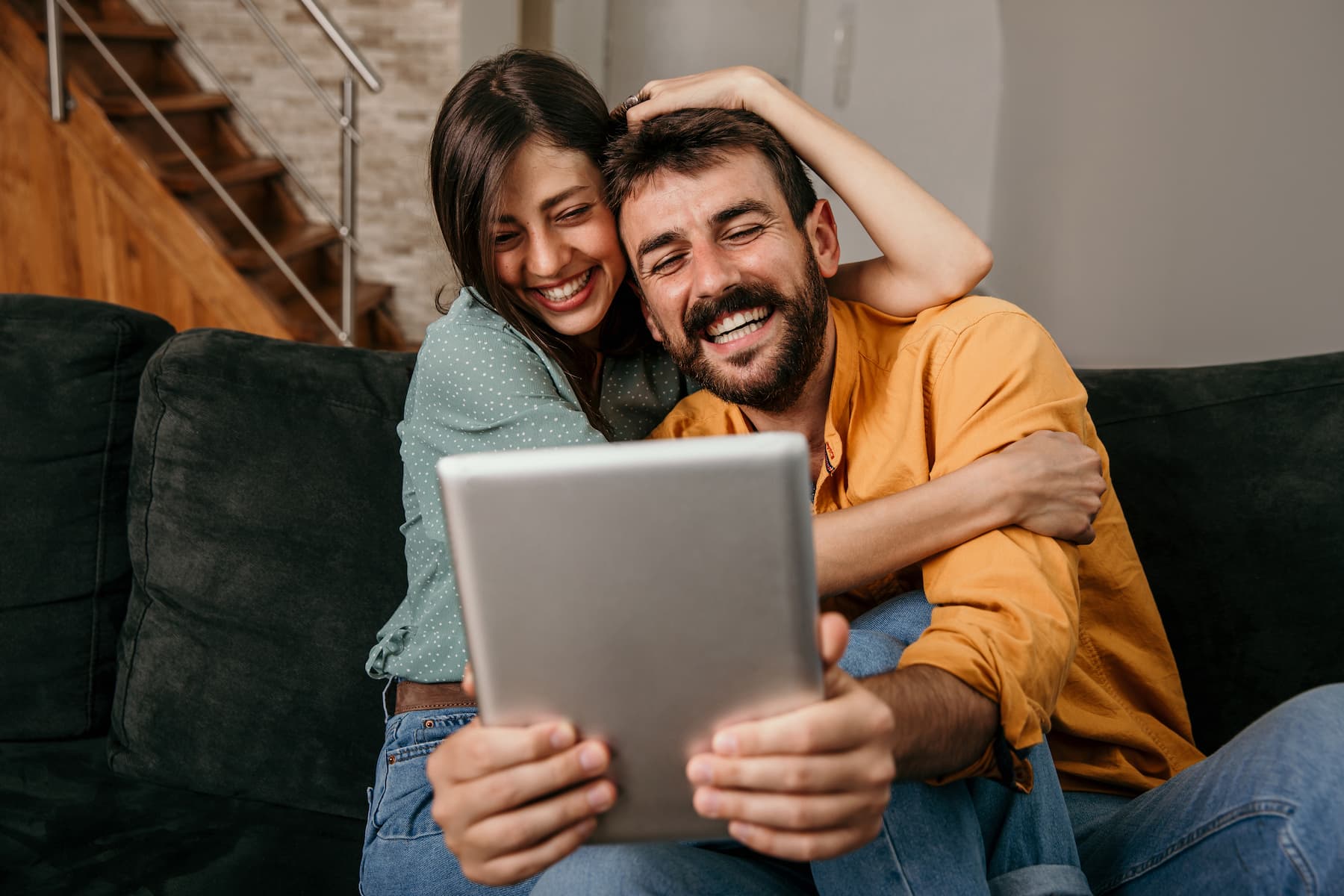 Ein junges Paar sitz gemeinsam vor einem Laptop