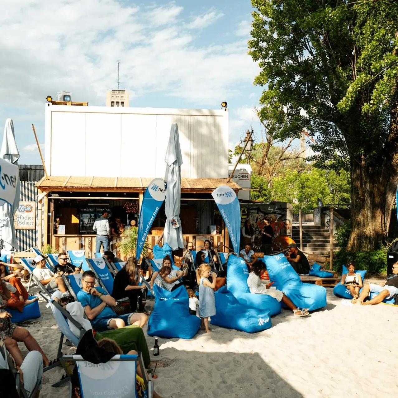 Unsere M-net Lounge auf dem M-net Kulturstrand. Es gibt bequeme Sitzkissen und eine Bar.