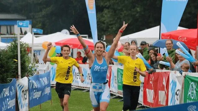 Teilnehmerin eines Triathlon läuft ins freudig ins Ziel
