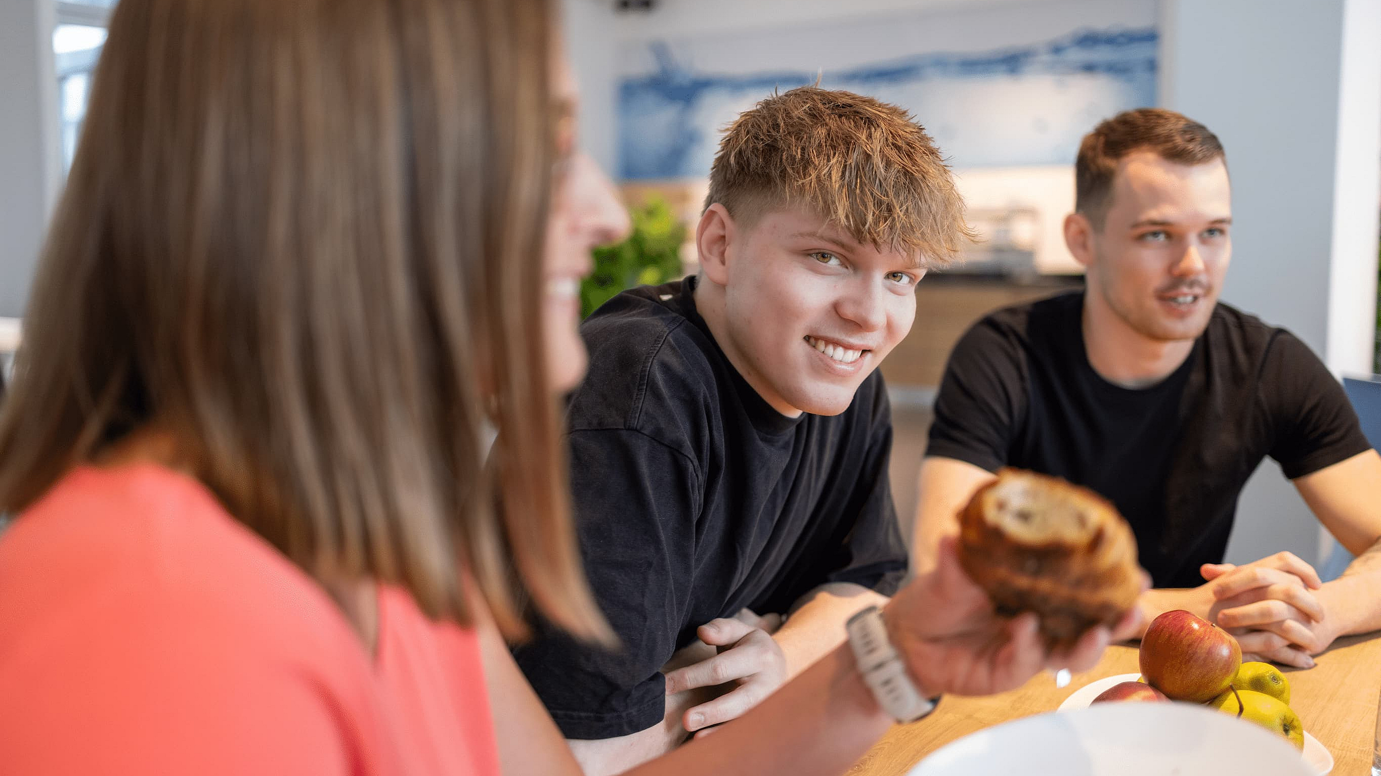 Zwei Kollegen und eine Kollegin beim gemeinsamen Frühstück bei M-net