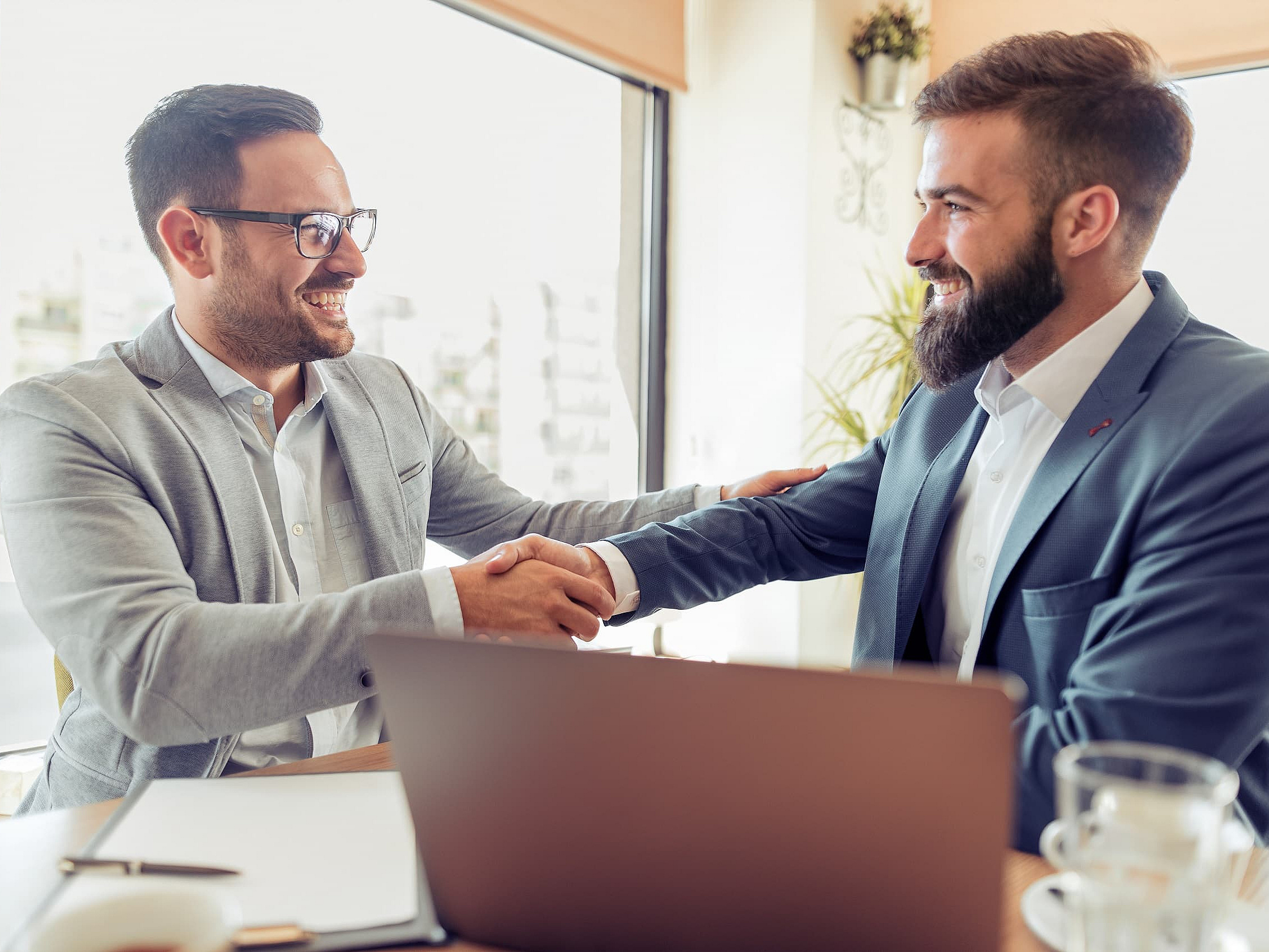 Zwei Geschäftspartner schütteln sich die Hände nach einem offensichtlich erfolgreichen Meeting