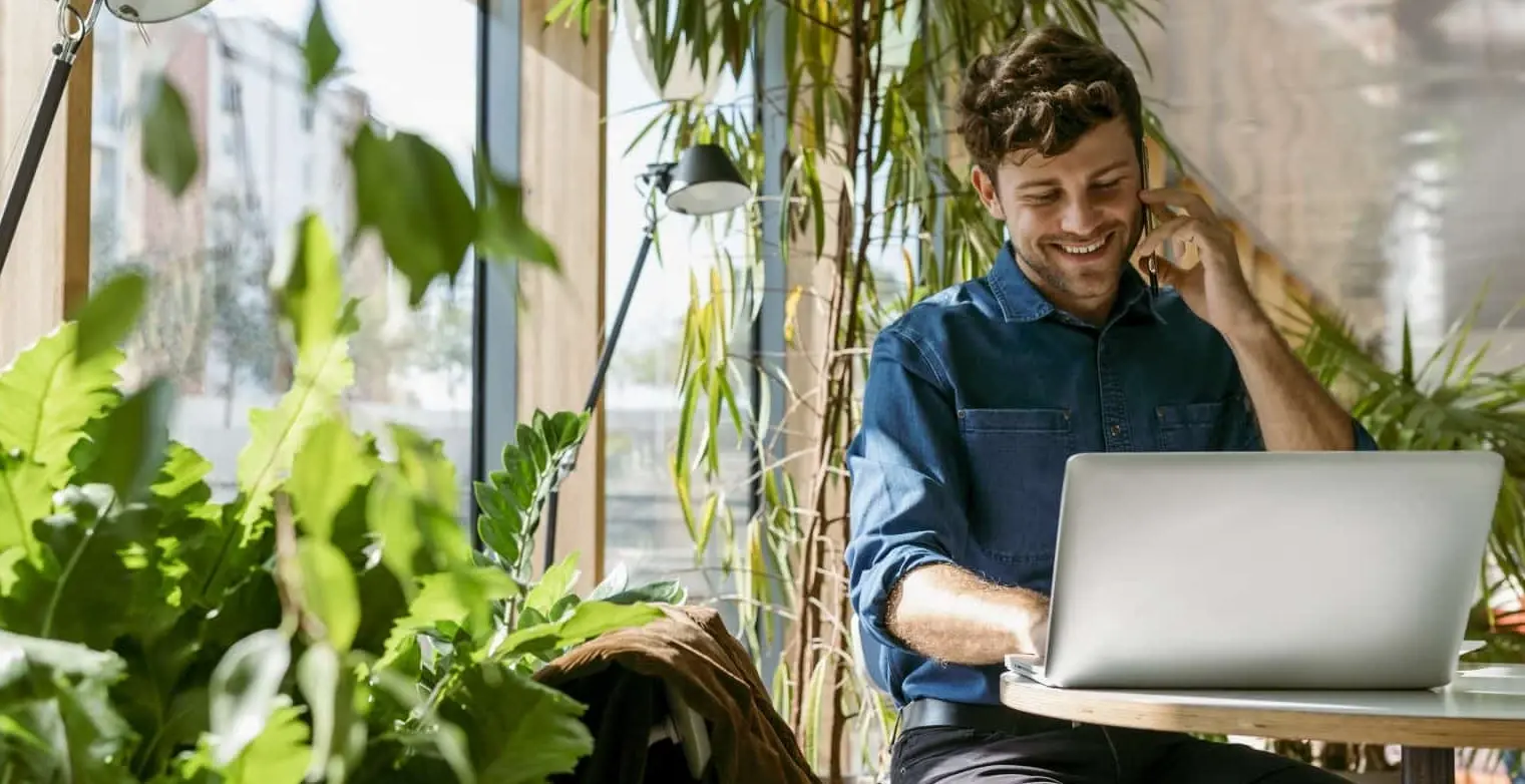 Ein Mann sitzt an einem Tisch vor seinem Laptop