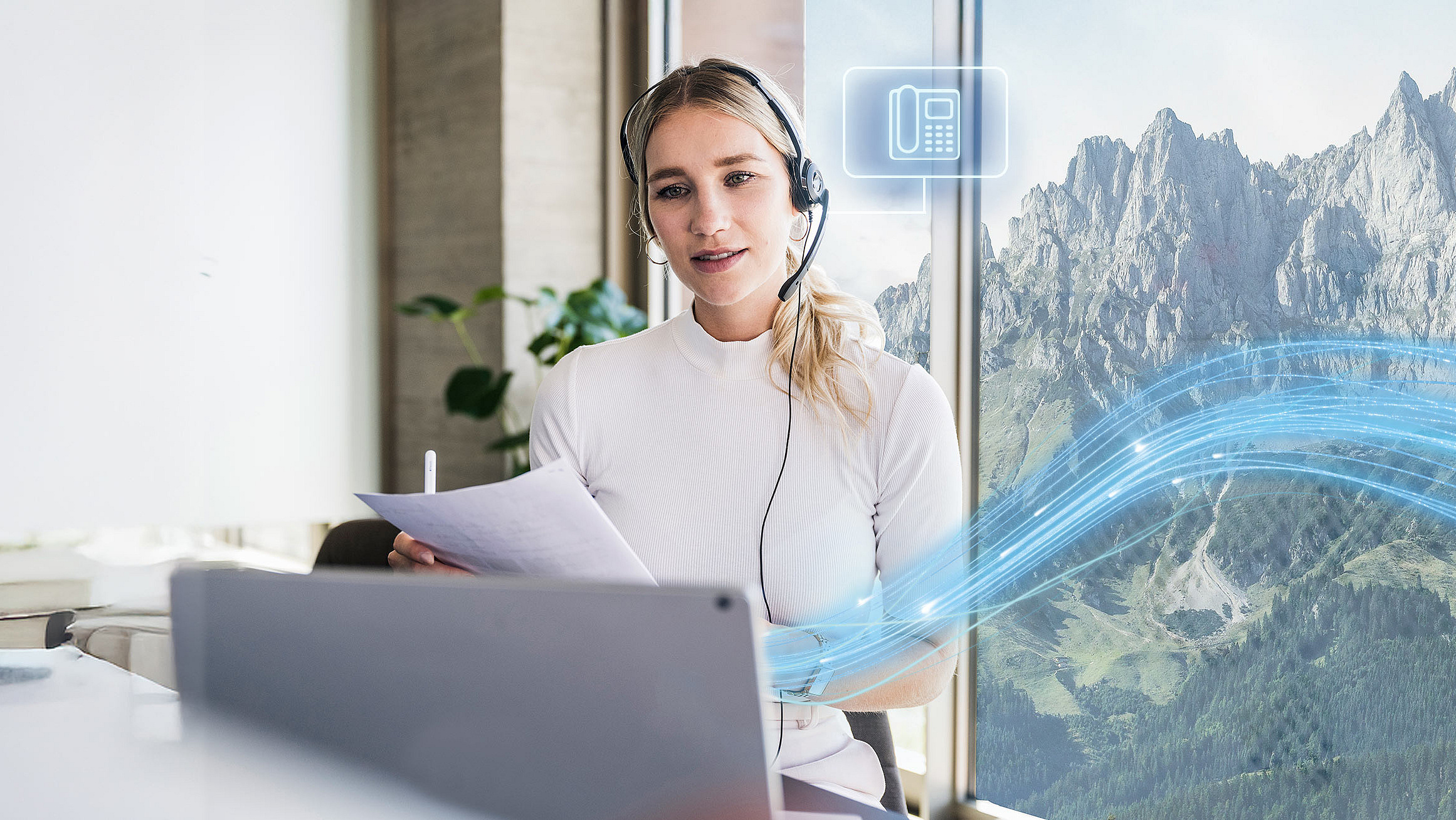 Mitarbeiterin im Support-Team nutzt digitale Telefonie im B&uuml;ro mit Alpenblick