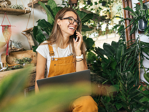 Frau telefoniert vor einem Laptop