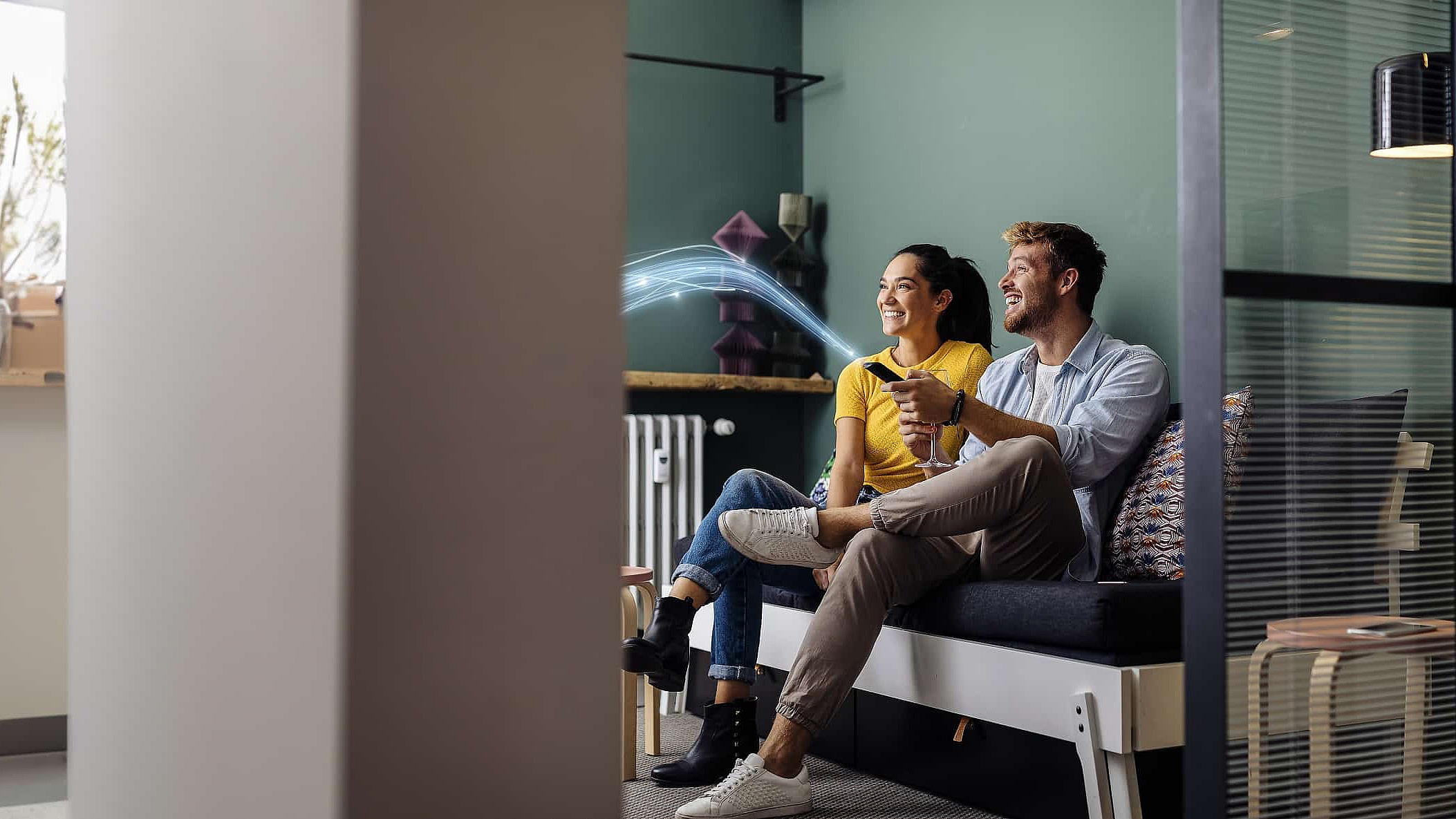 Paar sitzt auf dem Sofa und nutzt TVplus