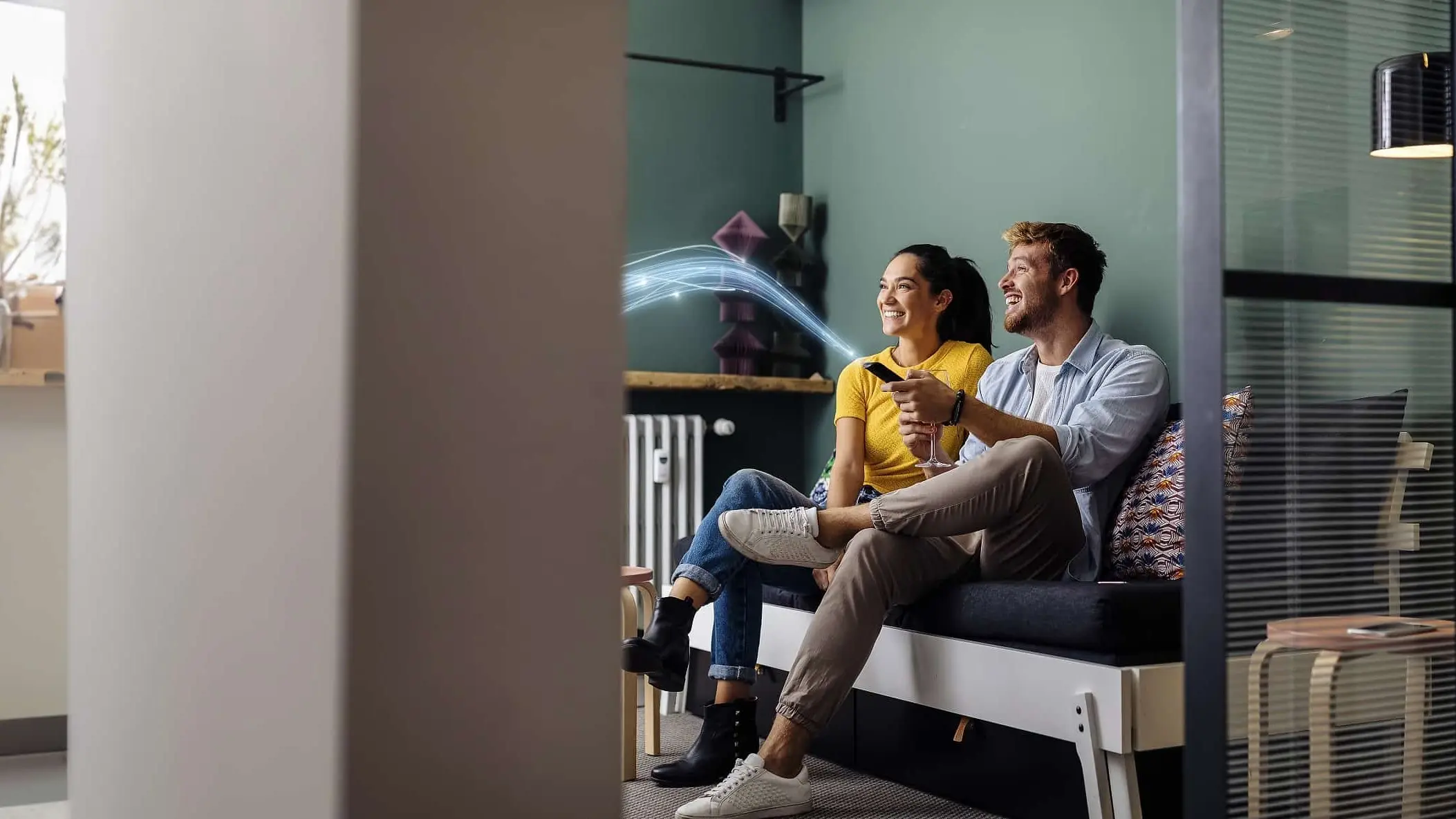 Paar sitzt auf dem Sofa und nutzt TVplus