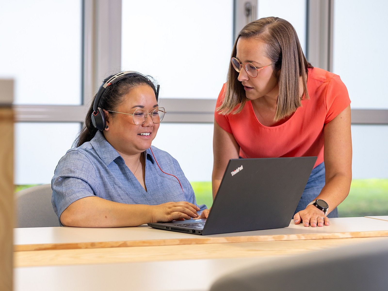 Zwei Mitarbeiterinnen im Gespräch vor einem Laptop