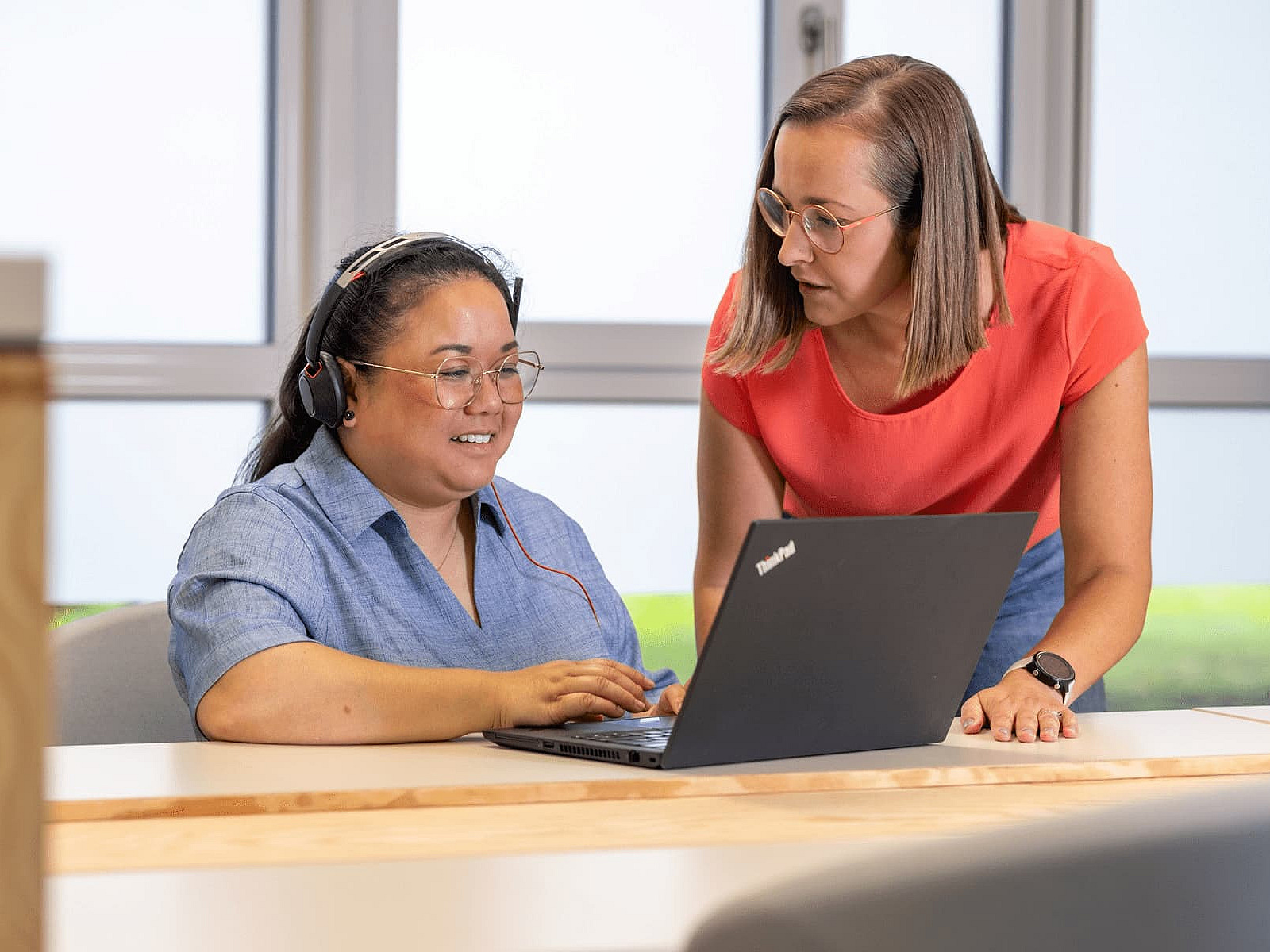 Zwei Mitarbeiterinnen im Gespräch vor einem Laptop