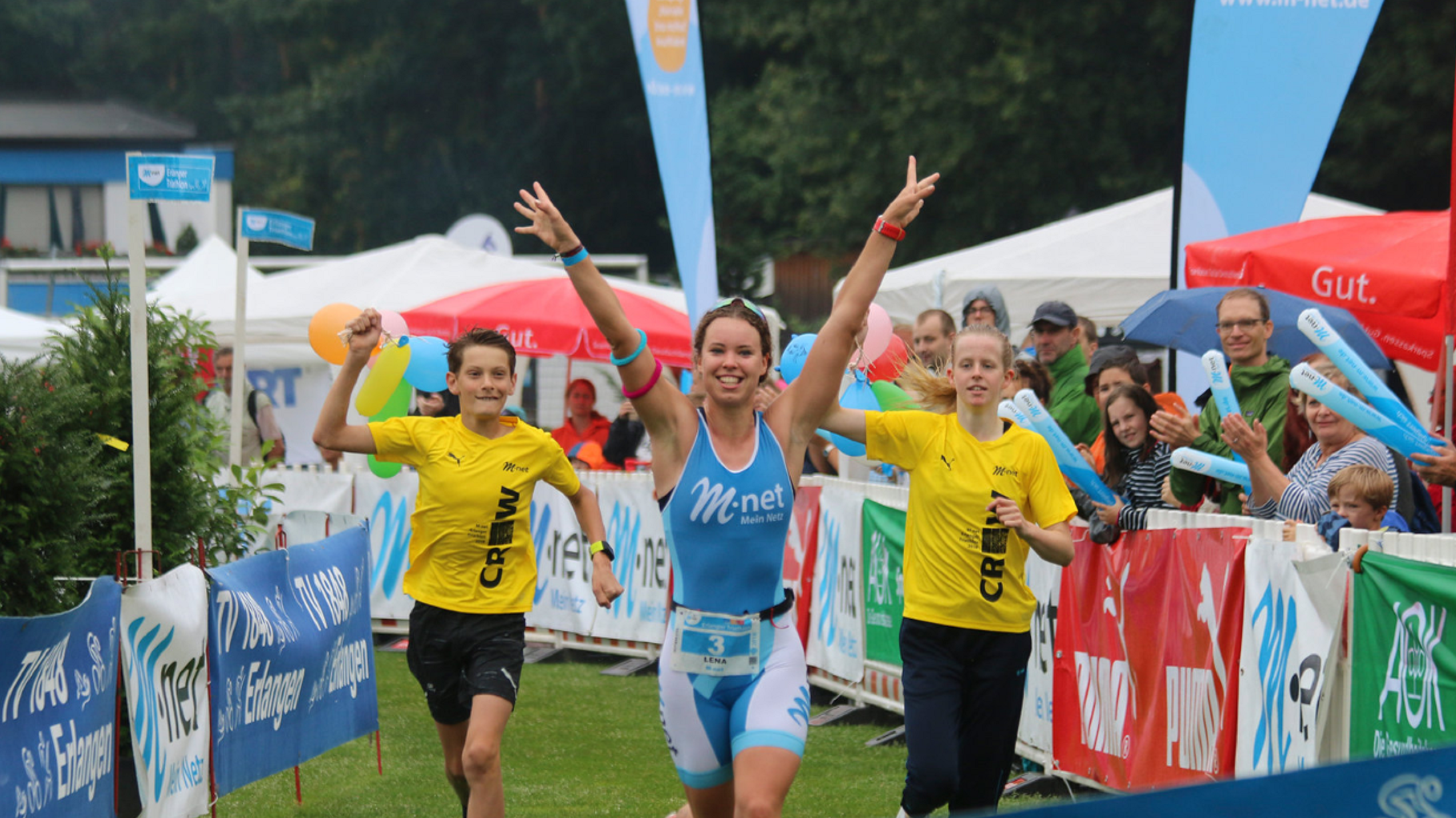 Teilnehmerin eines Triathlon läuft ins freudig ins Ziel