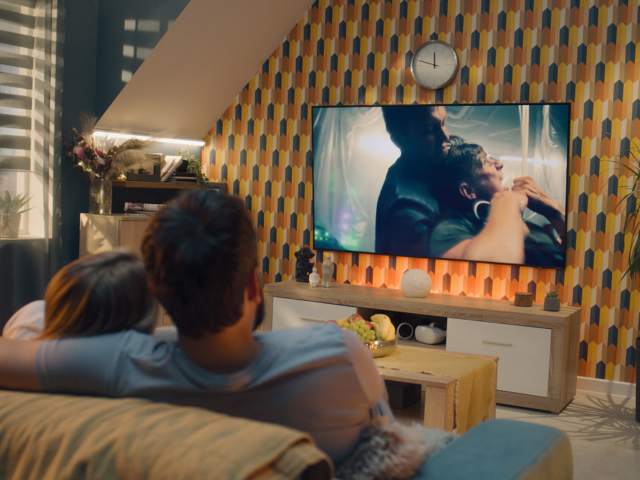 Paar sitzt auf dem Sofa und sieht fern