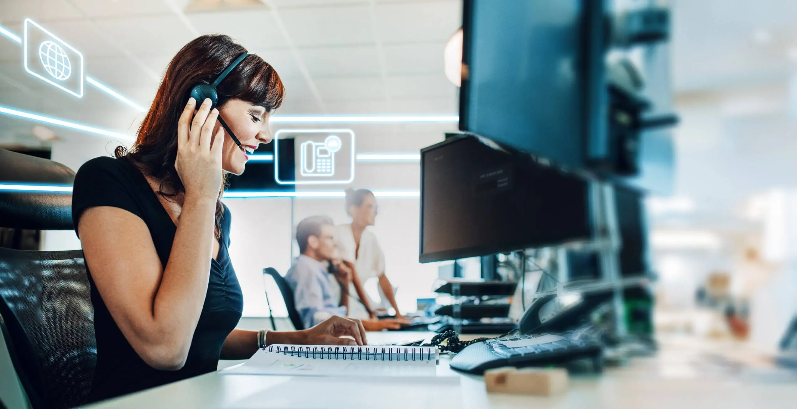 Frau mit Headset f&uuml;hrt ein Gespr&auml;ch im modernen B&uuml;ro