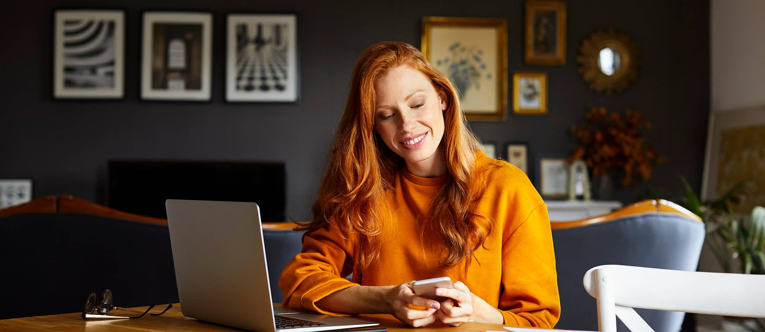 Eine Frau sitzt zuhause an einem Tisch und schreibt