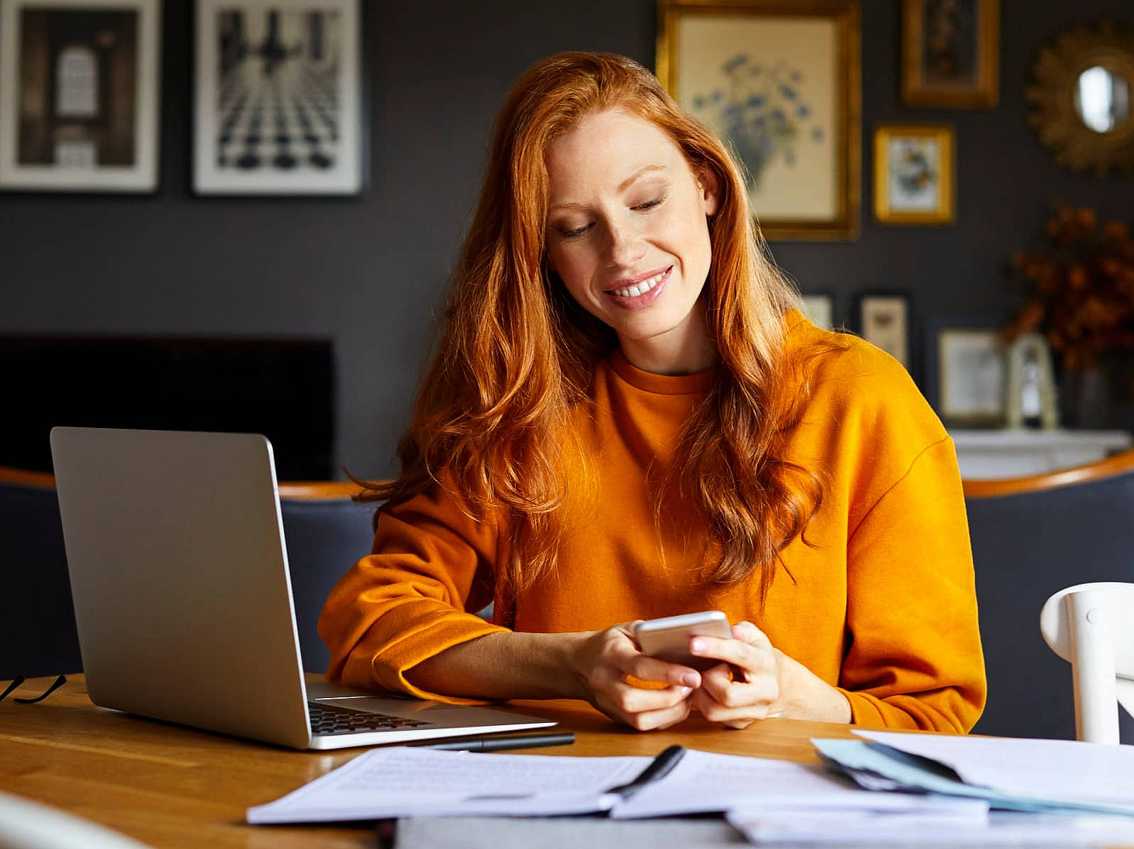 Frau sitzt am Tisch vor Laptop und scheint etwas zu installieren