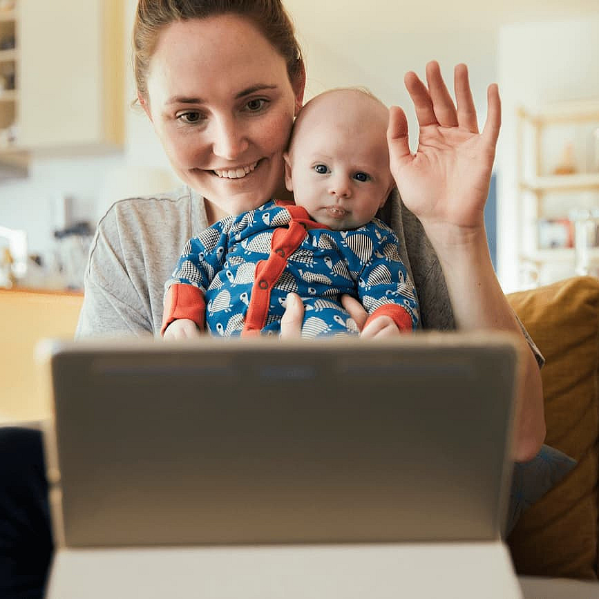 Frau mit Baby vor einem Bildschirm