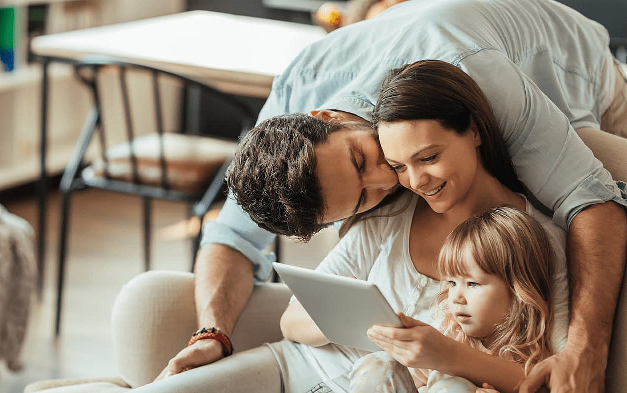 Eine Familie schaut gemeinsam in den Laptop