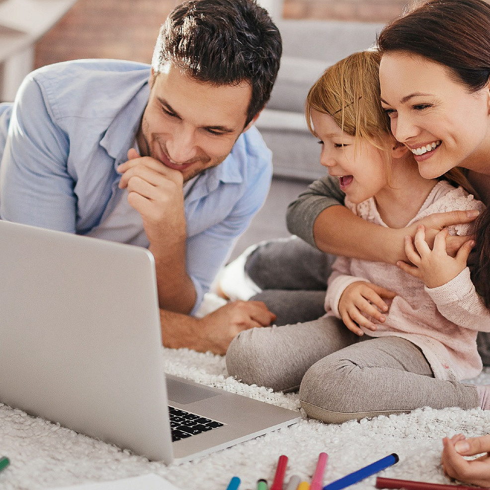 Vater, Mutter und Kind vor einem Laptop