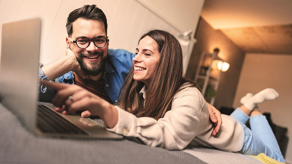 Paar vor dem Laptop scheinbar im Internet surfend