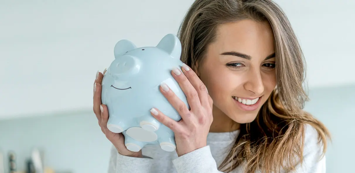 Eine Frau hat ein Sparschwein in der Hand