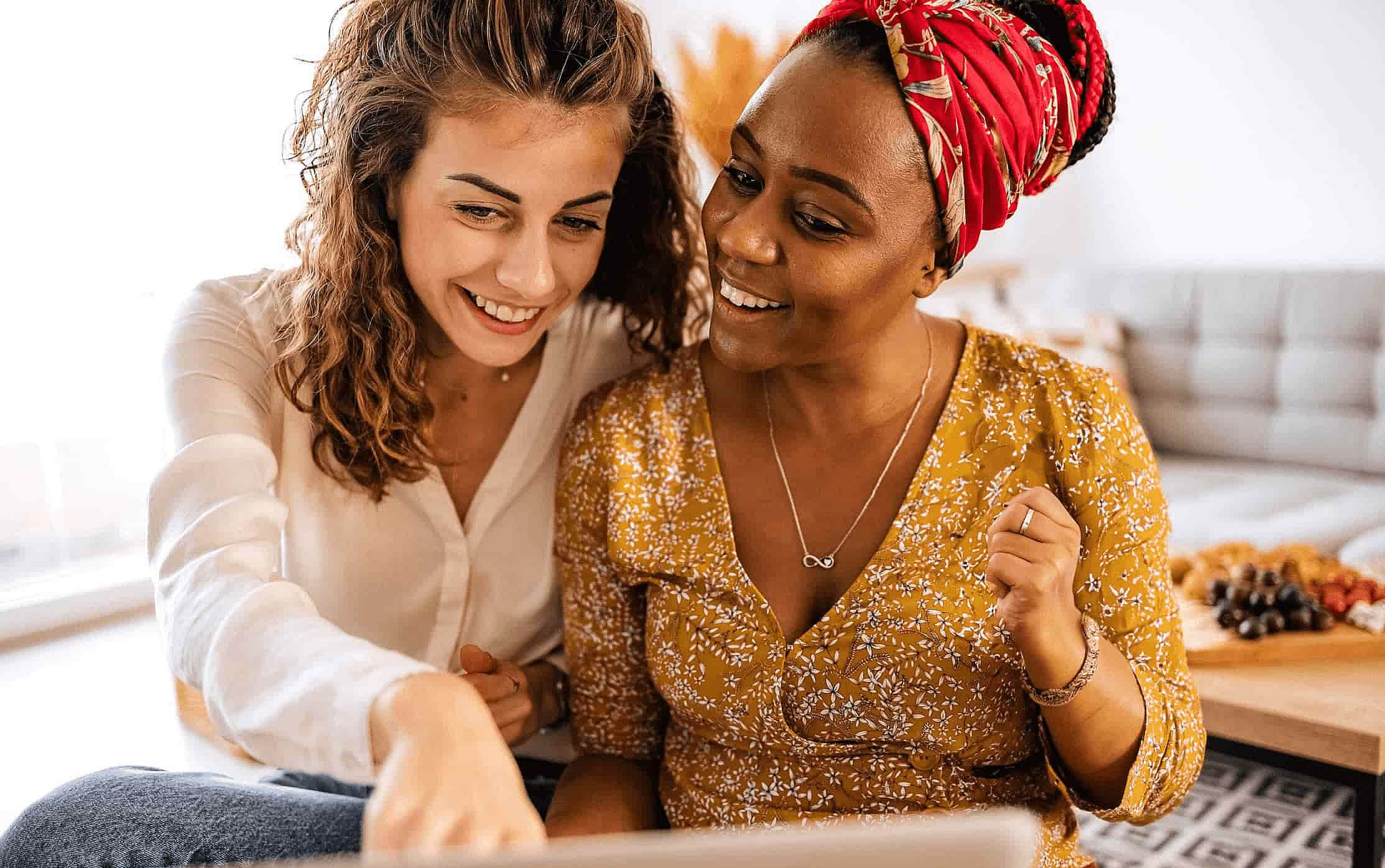 Zwei Frauen sitzen gemeinsam vor dem Laptop