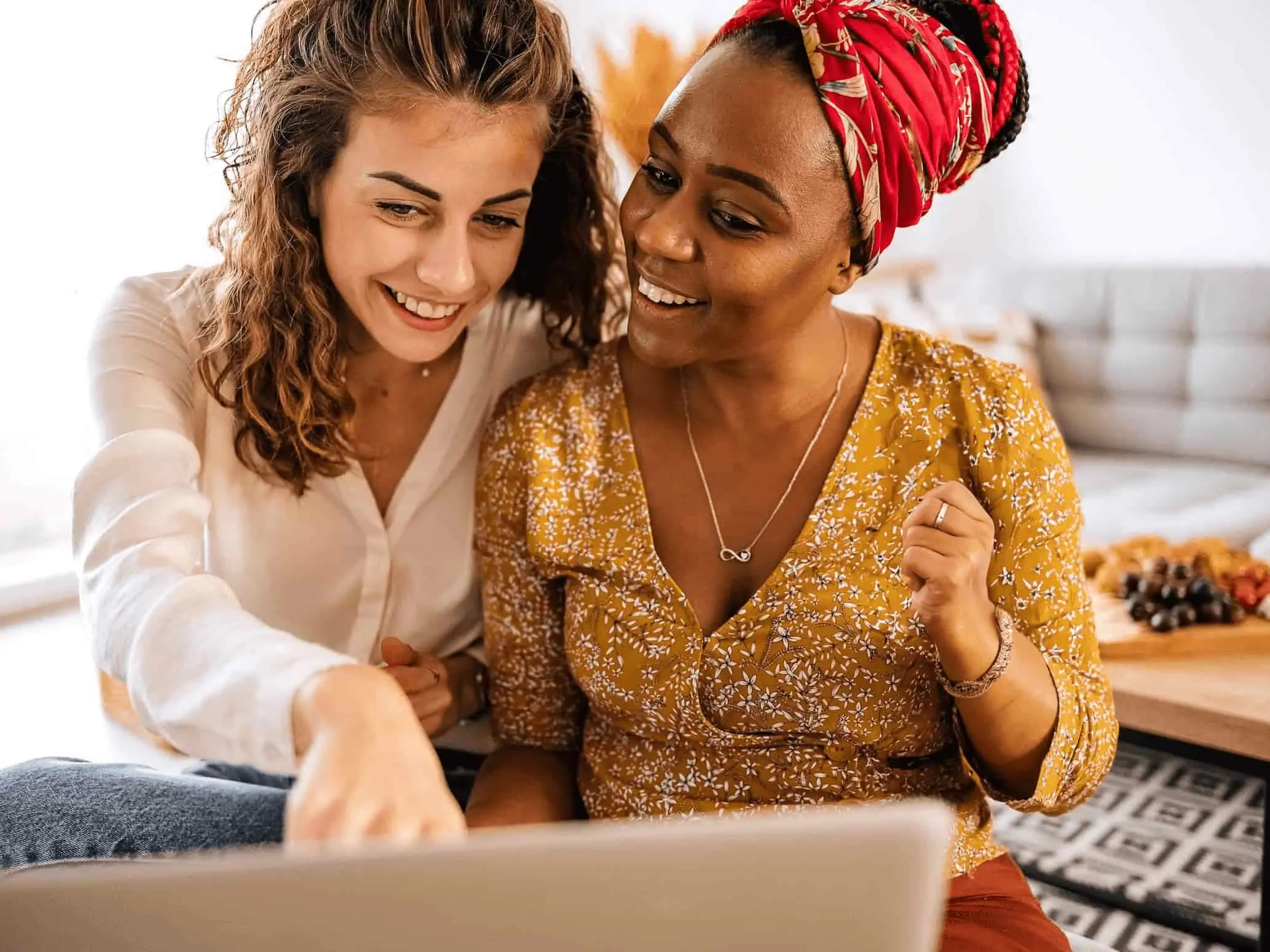 Zwei Frauen sitzen gemeinsam vor einem Laptop