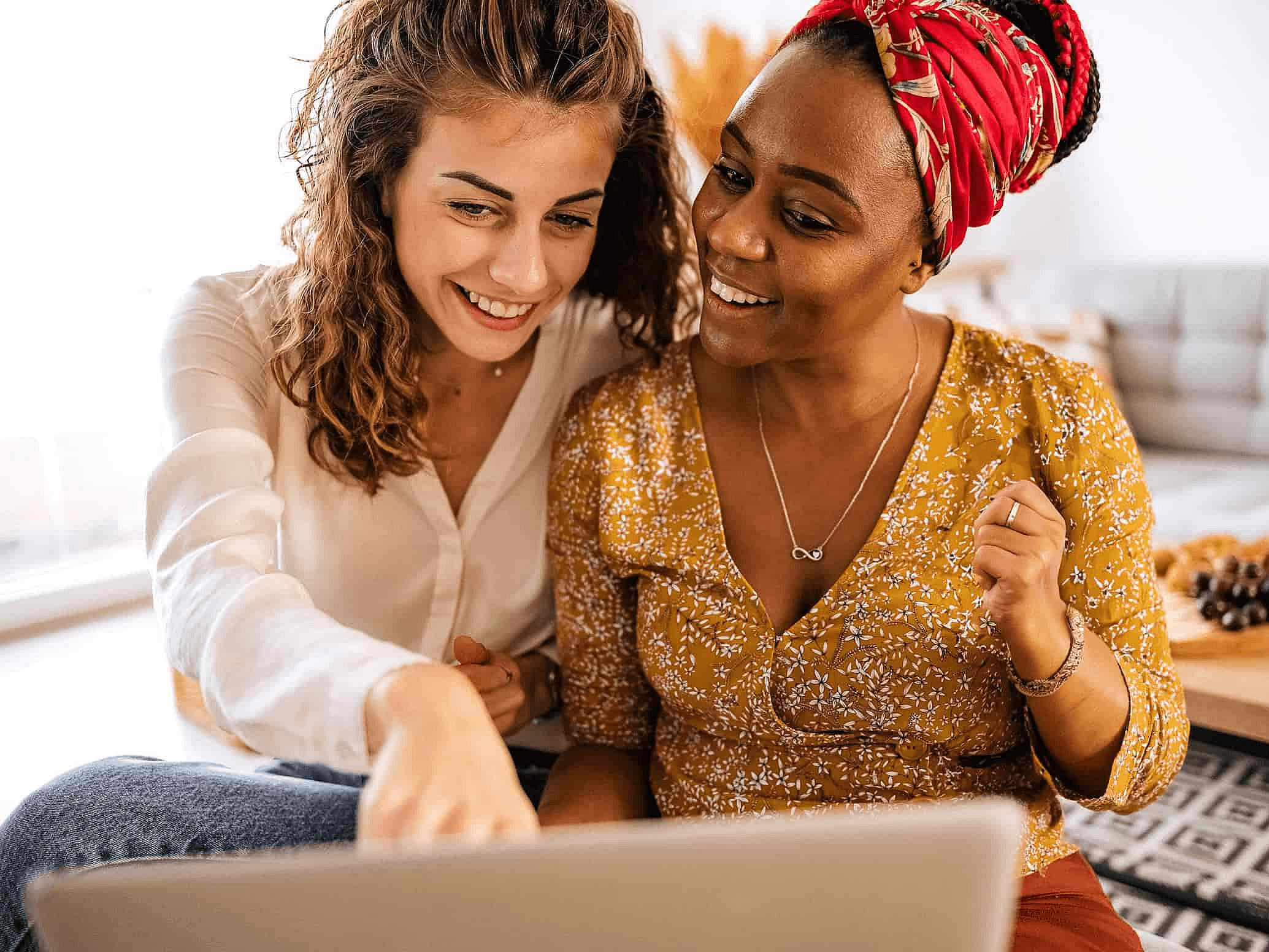 Zwei Frauen schauen gemeinsam in einen Laptop