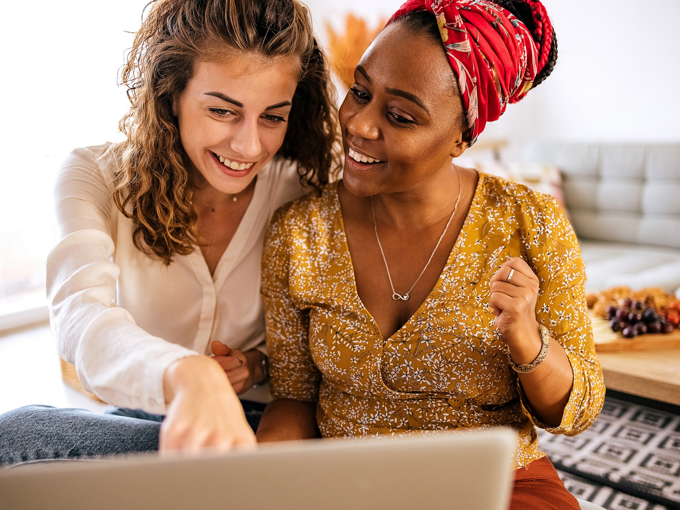 Zwei Frauen lesen gemeinsam im Internet vor einem Bildschirm