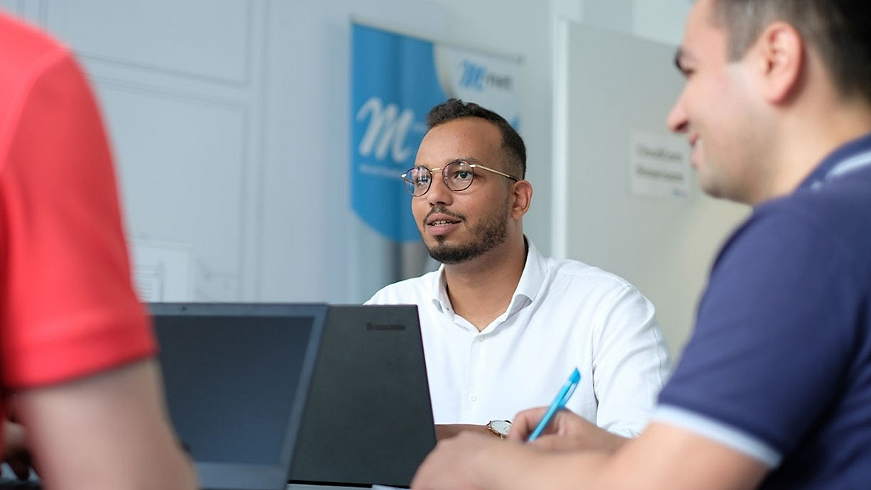Mitarbeiter sitzen in einem Meeting und symbolisieren Zusammenarbeit